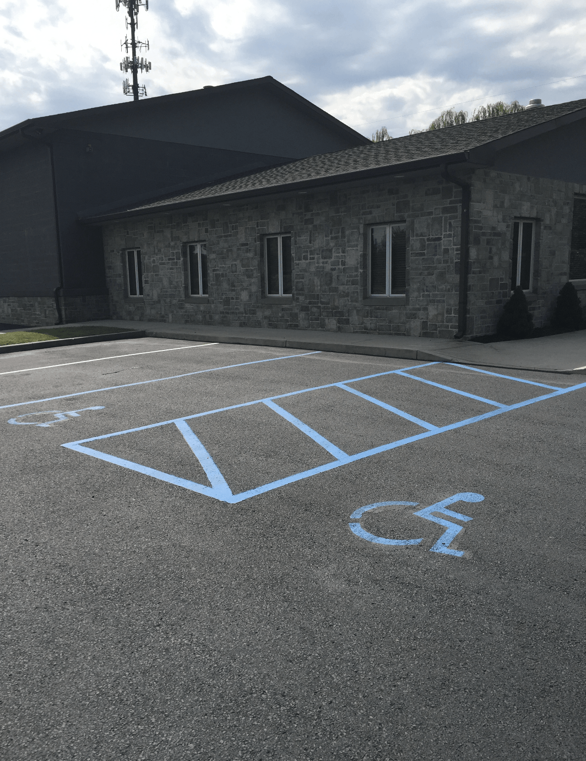 A handicapped parking space is painted blue in front of a building