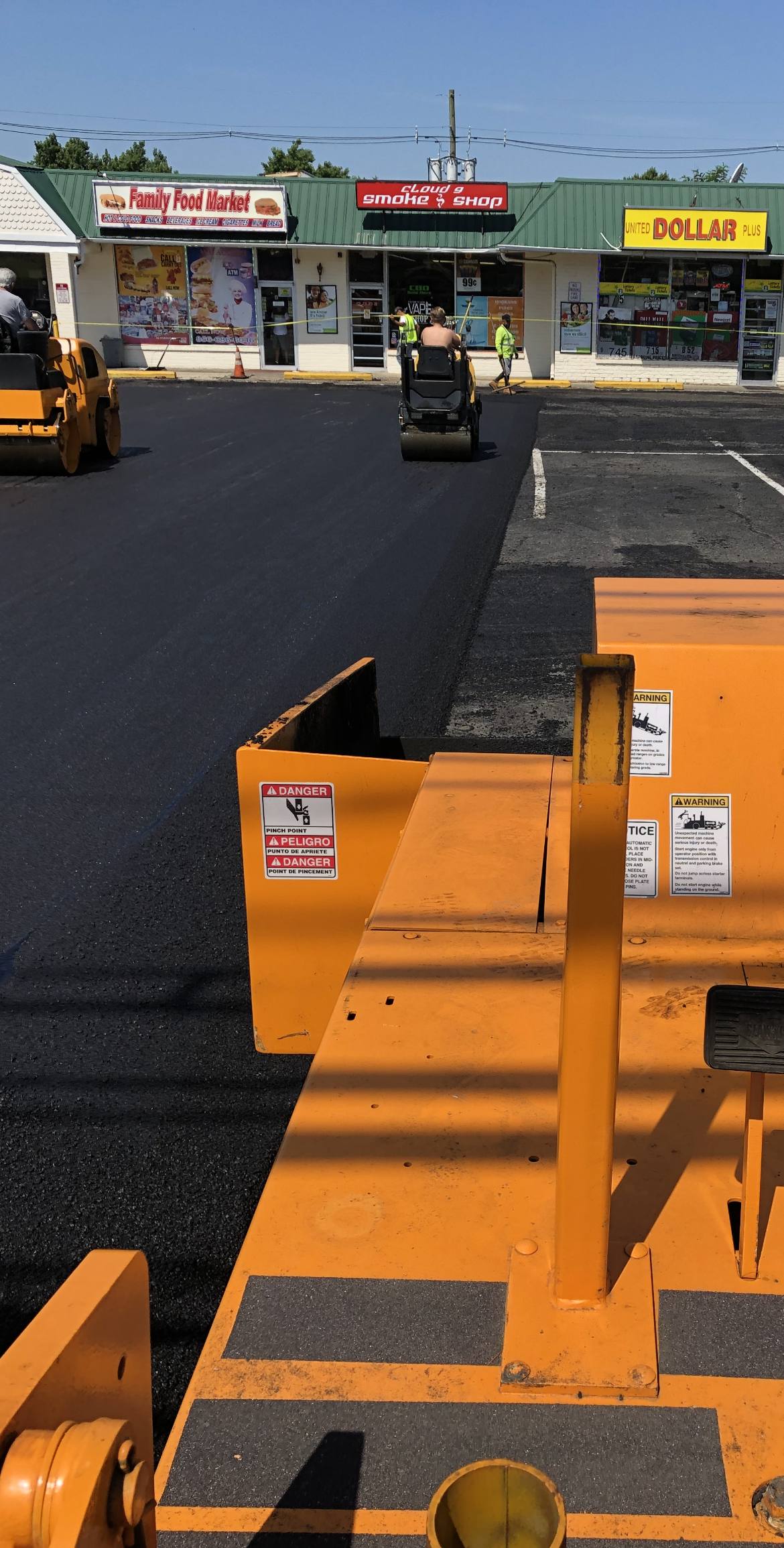 An asphalt machine is laying asphalt in a parking lot