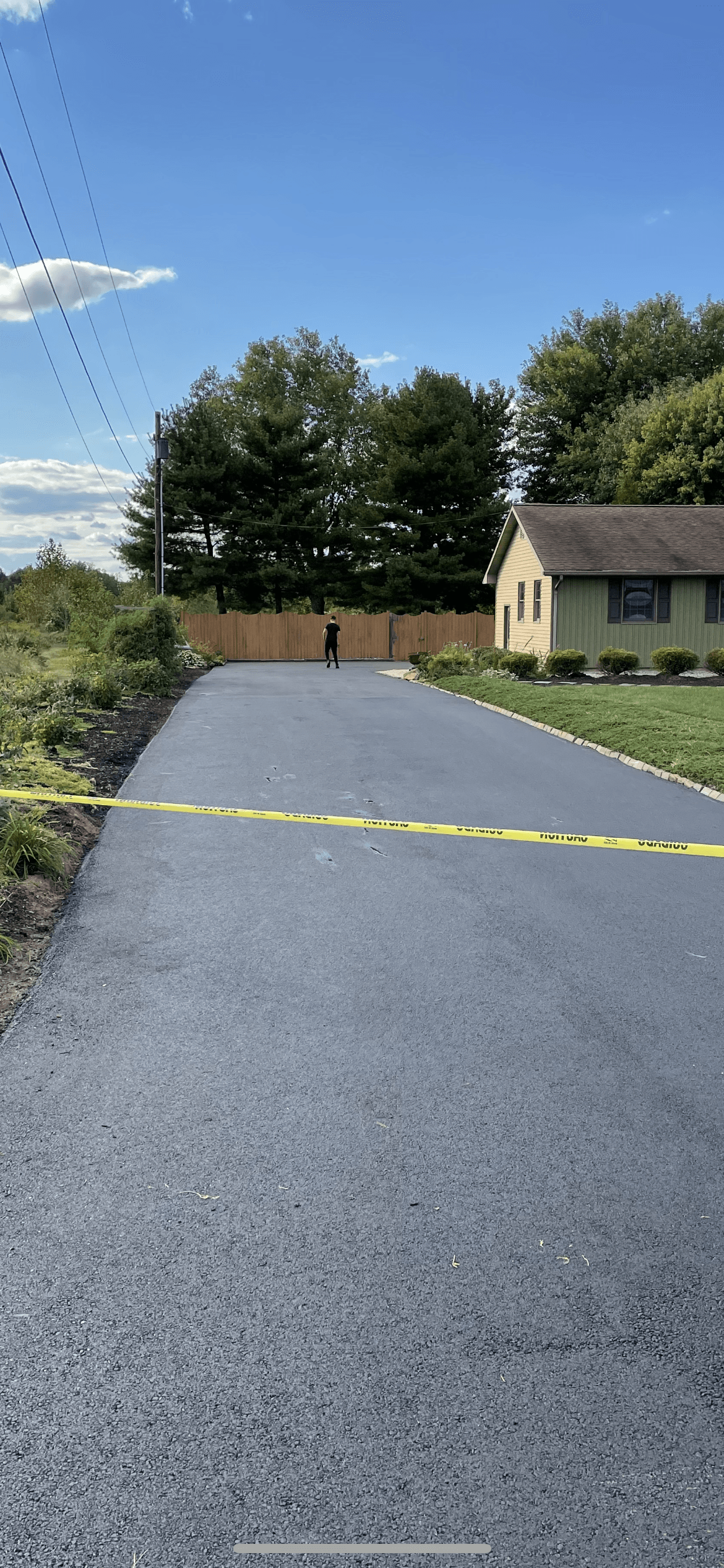 Asphalt driveway with a house in the background