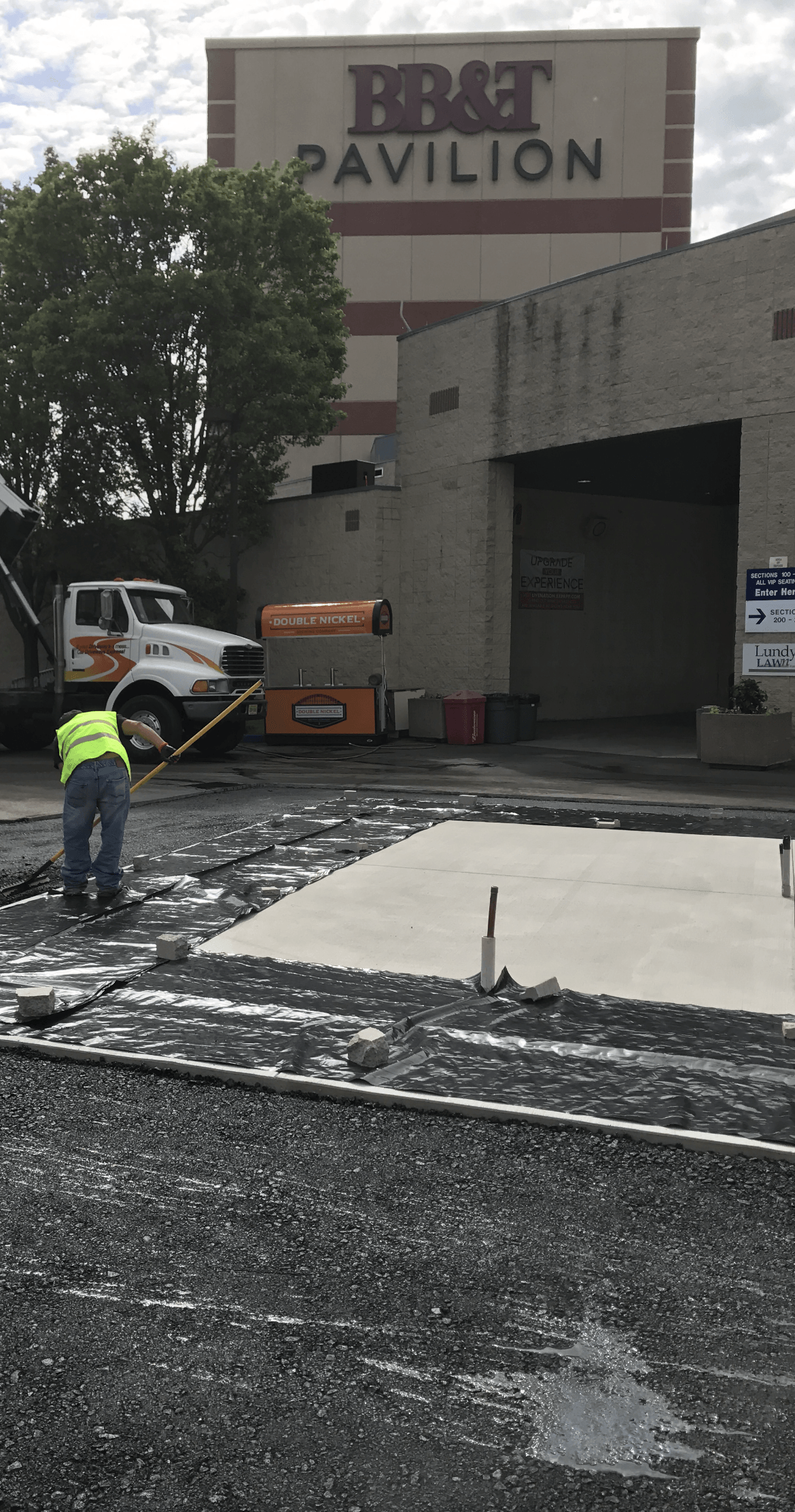 Man working on a concrete slab in front of a building
