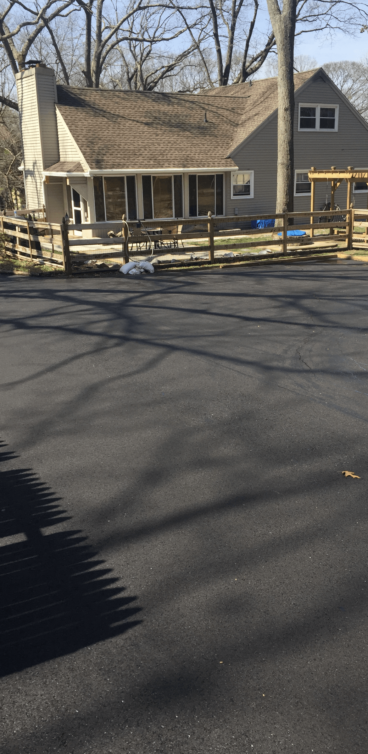 A house with a porch and a wooden fence in front of it