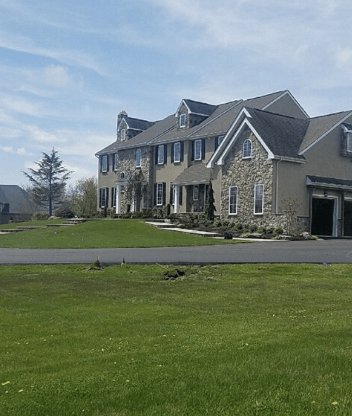 A large house with a lush green lawn in front of it