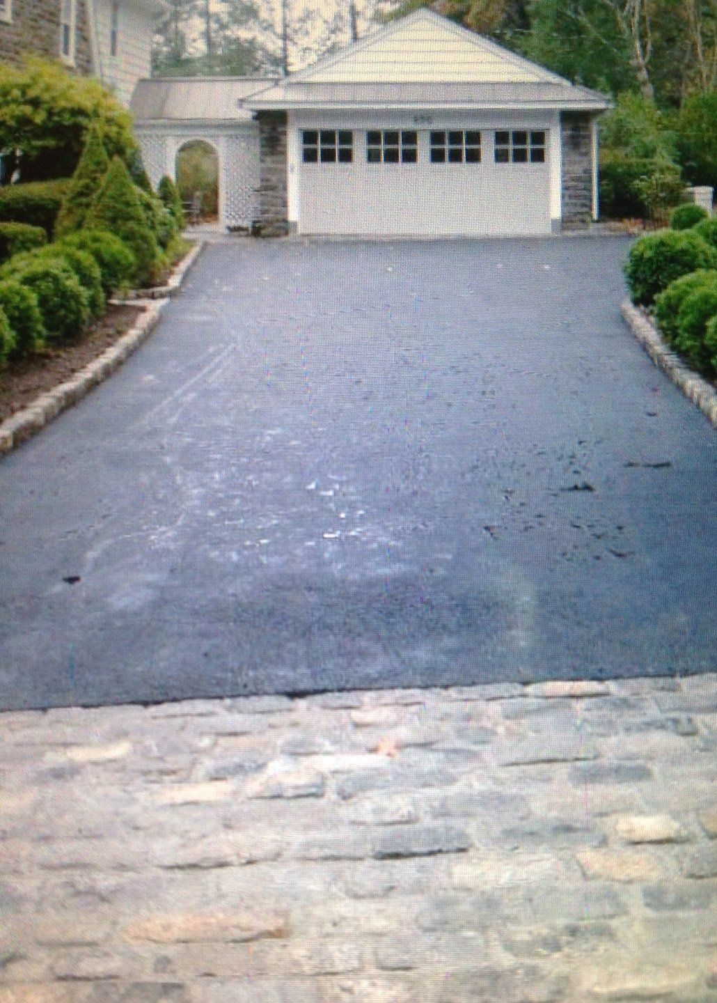 Driveway leading to a garage with a white garage door