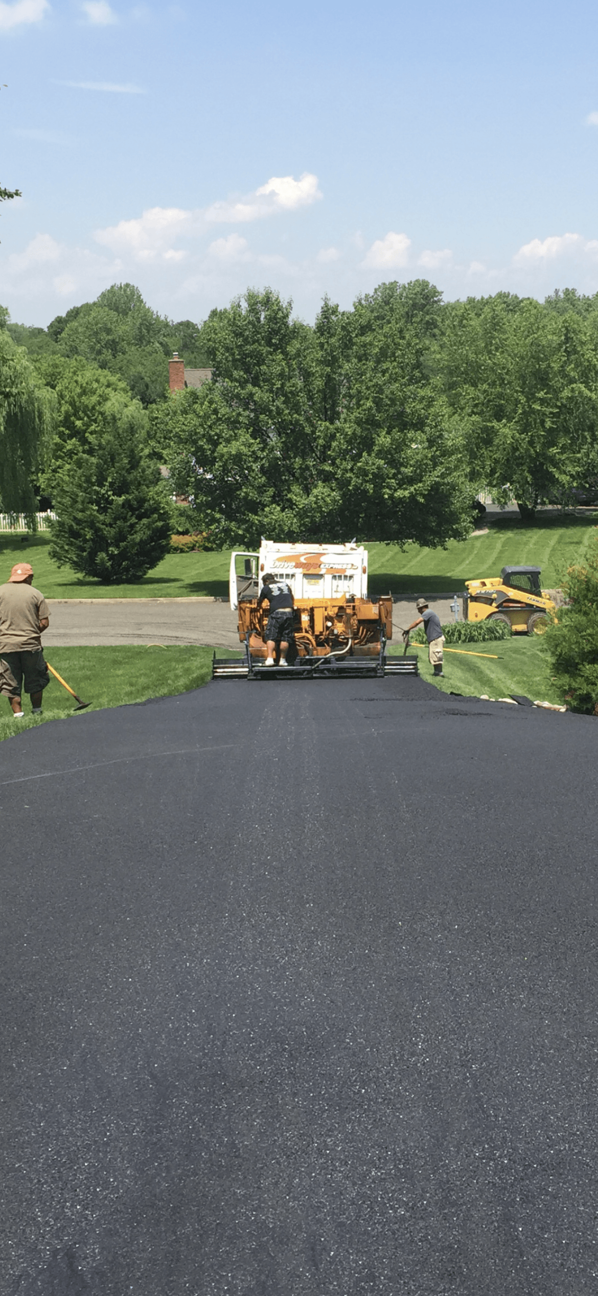 A truck is spreading asphalt on a road