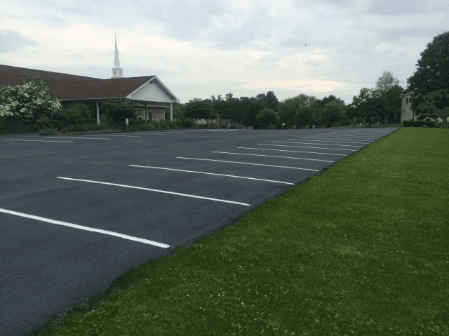 An empty parking lot with a church in the background