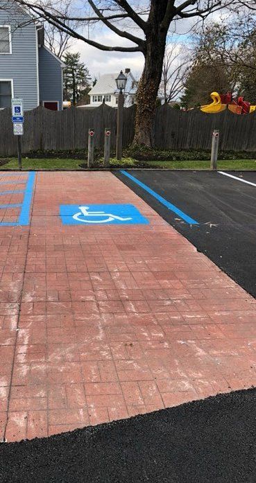 A handicapped parking spot is painted blue in a parking lot.