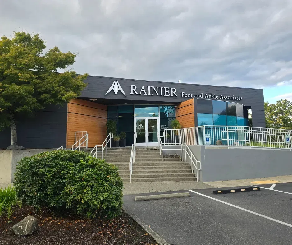 Rainier Financial branch, modern building with dark exterior, steps leading to the glass entrance, and overcast sky.