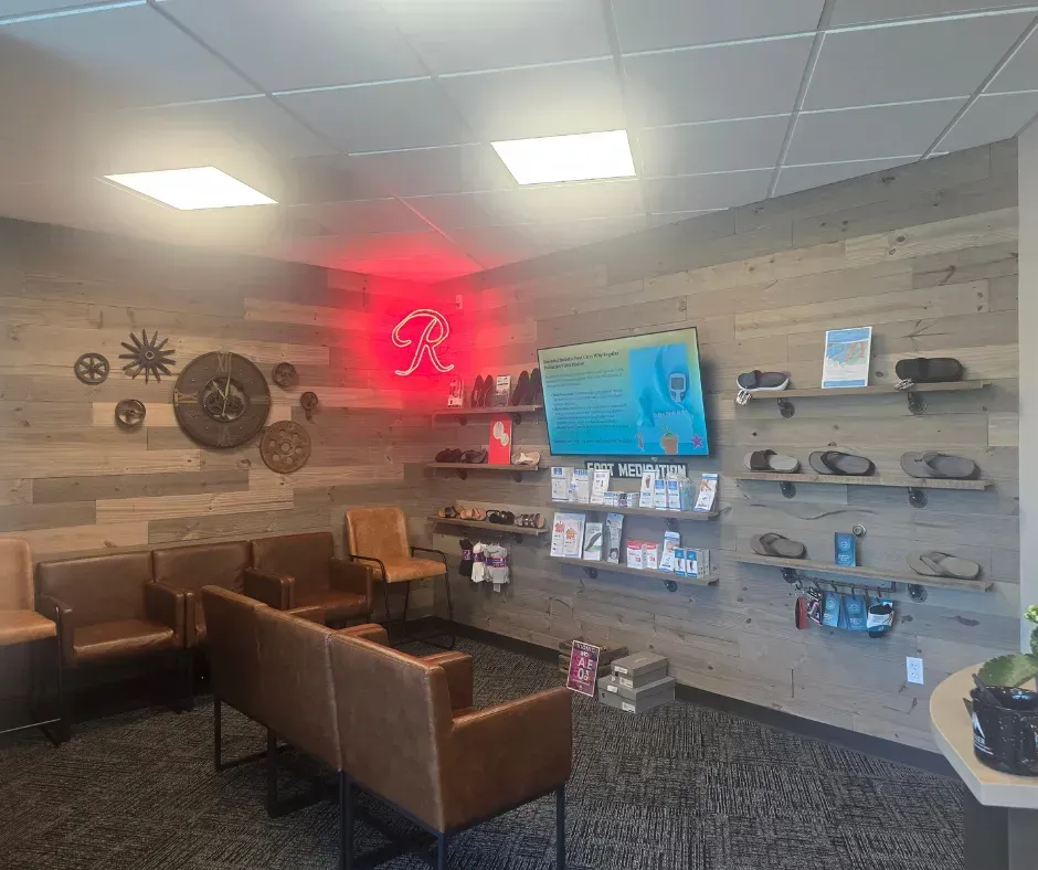 A waiting room with brown leather seating, wood-paneled walls, and shelves with displayed products.