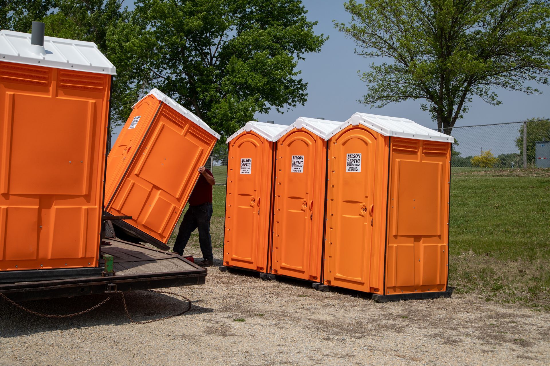 A man is loading portable toilets into a truck