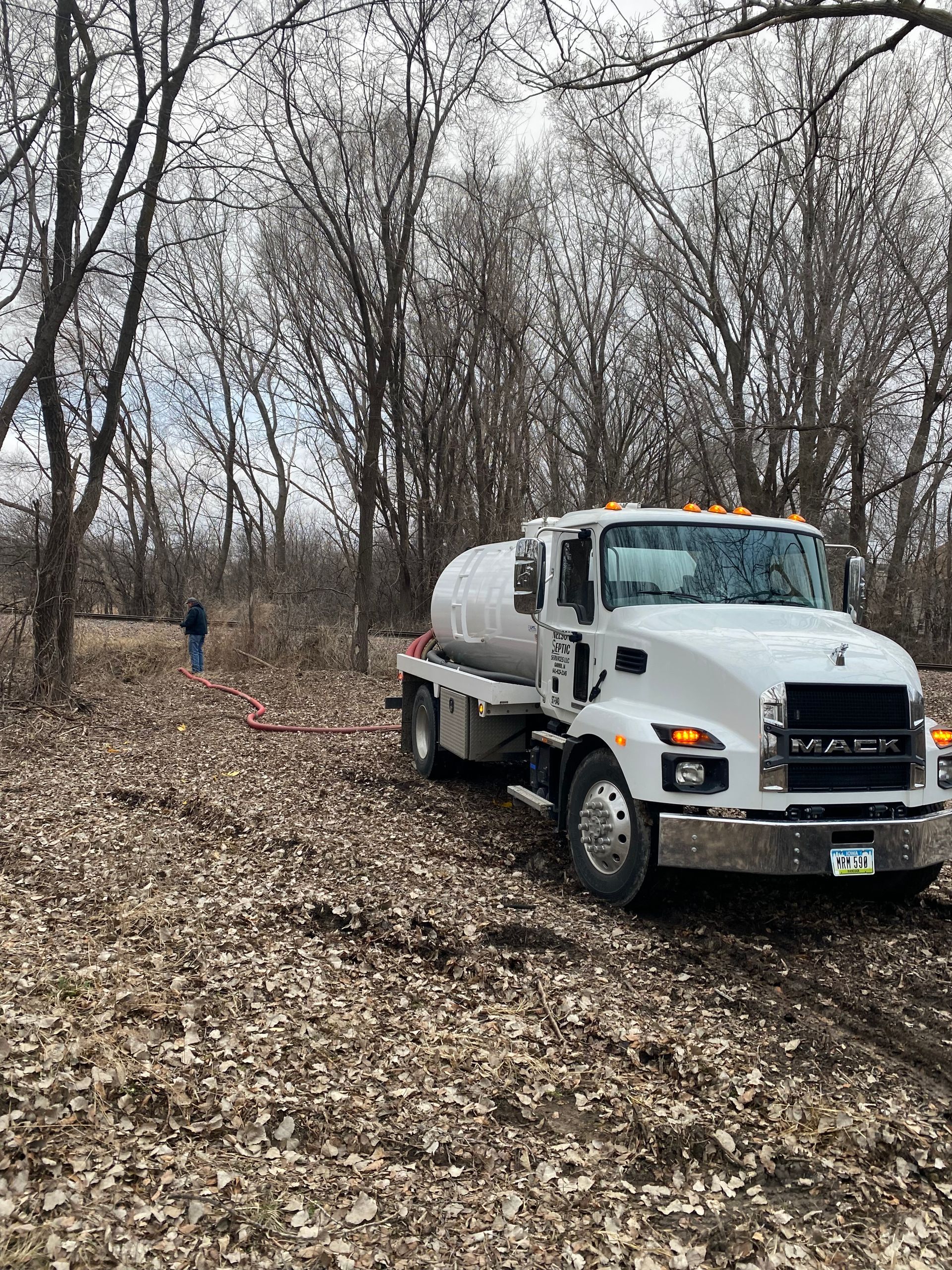 A white truck is parked in a field of leaves