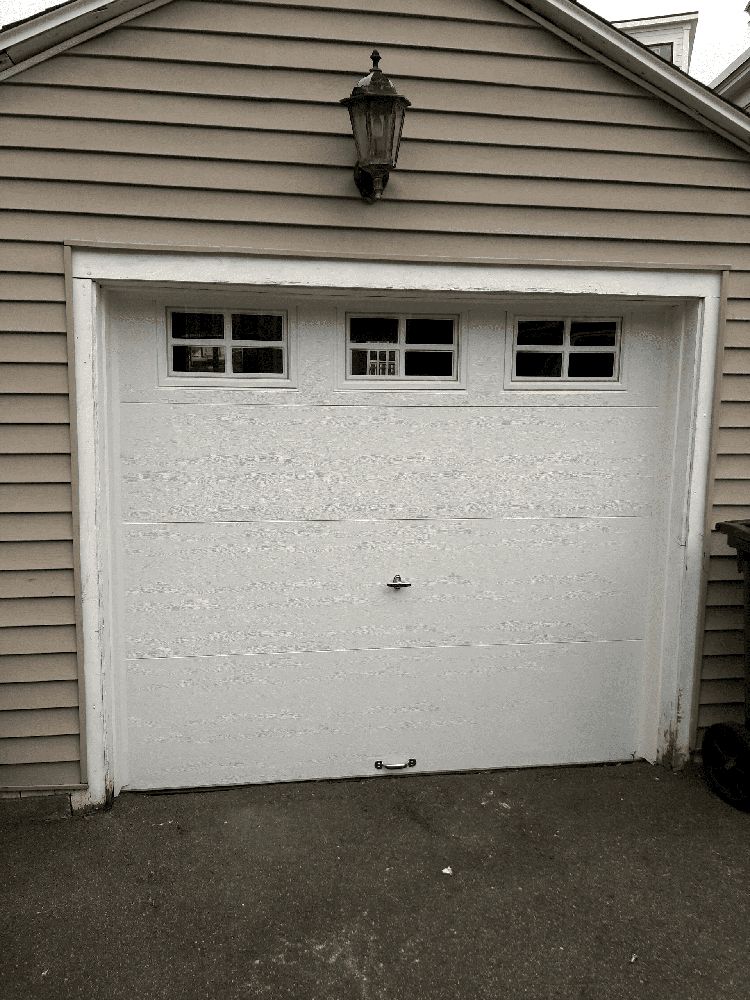 A white garage door with a light on top of it