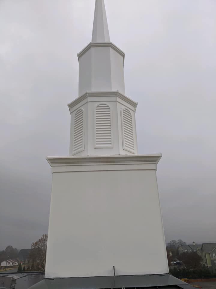 White church steeple against a gray cloudy sky