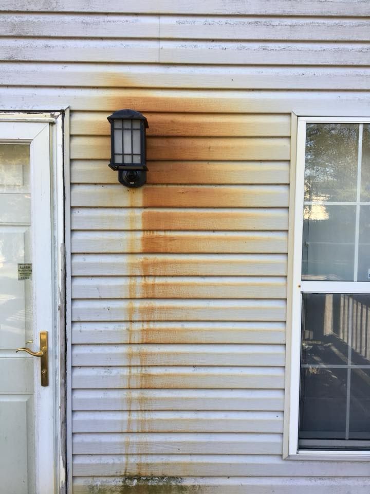 House siding with a wall-mounted lantern between a door and a window