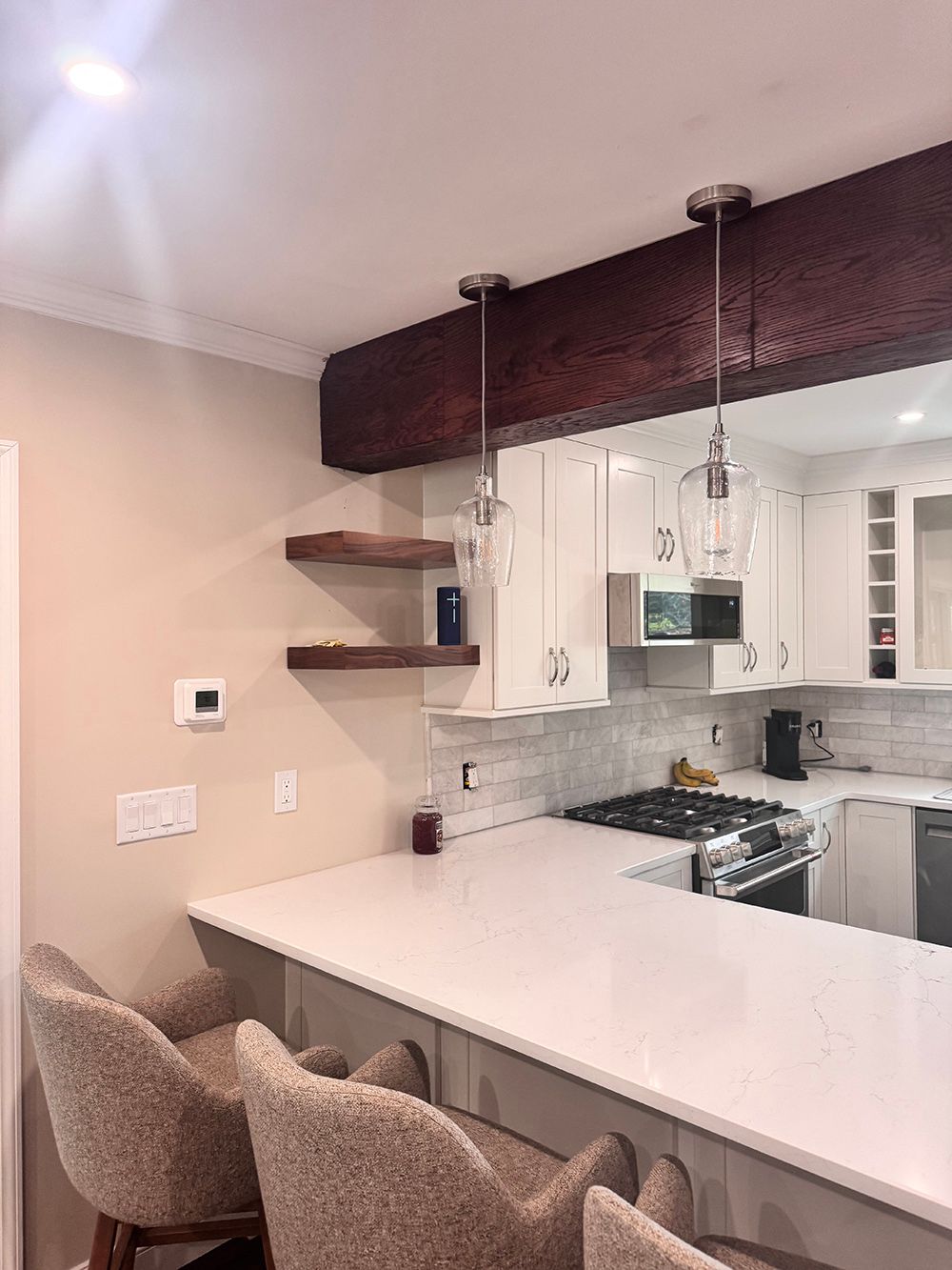 Modern kitchen with a white island, pendant lights, barstools, and open shelves