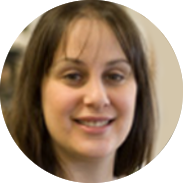 Woman with brown hair smiling indoors.