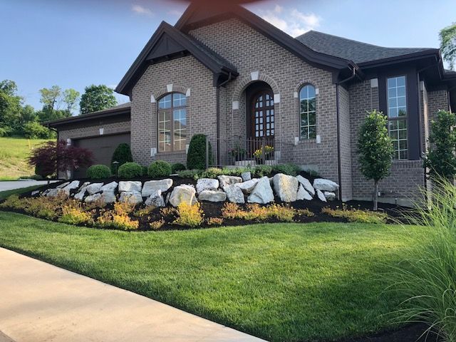 A large brick house with a lush green lawn in front of it