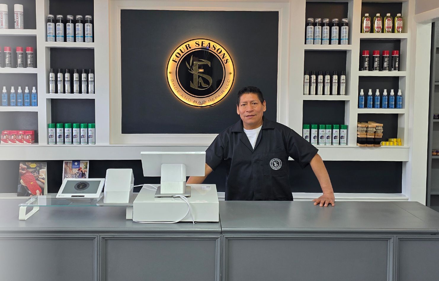 A man is standing behind a counter in a store.