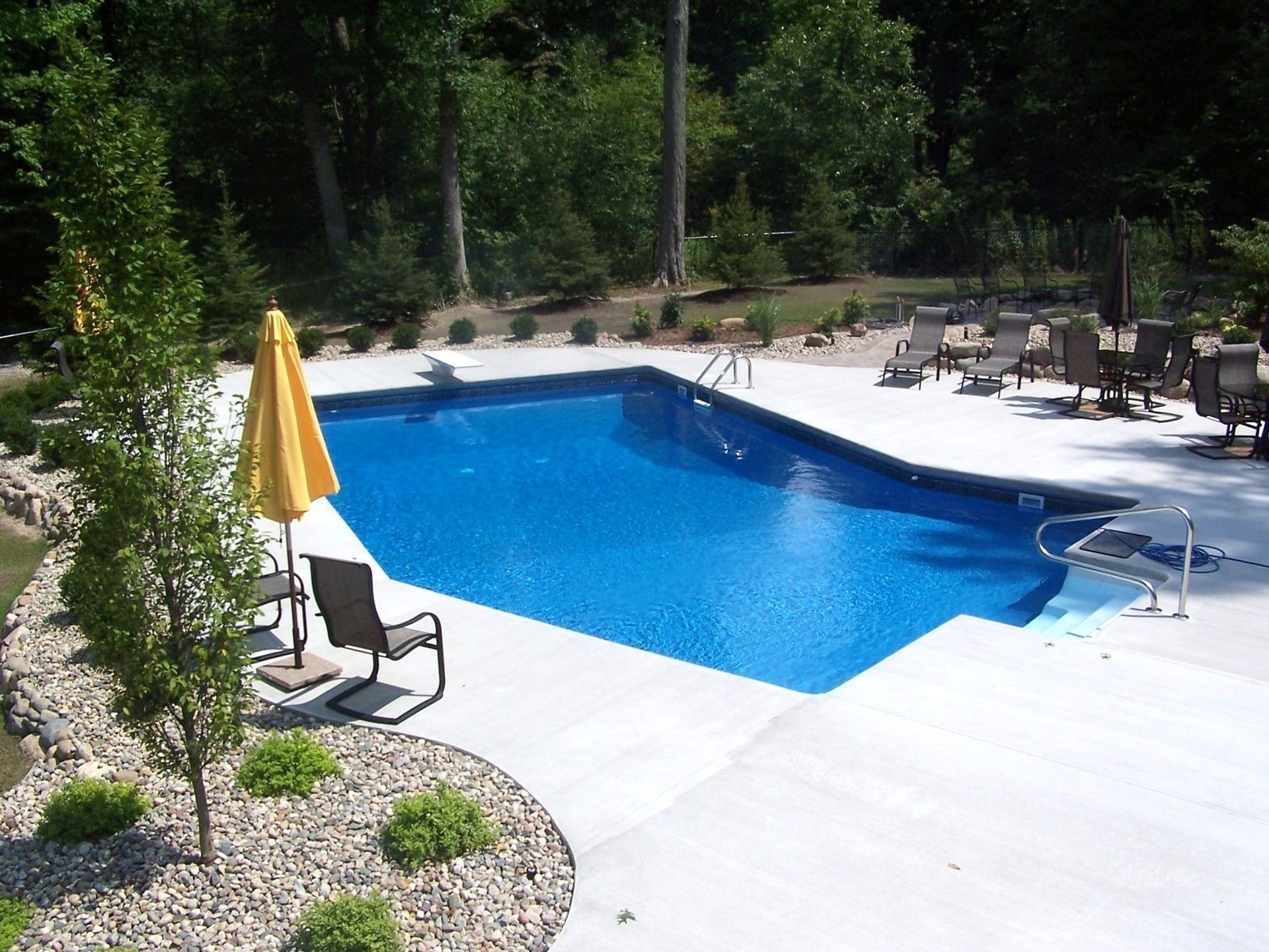 A large swimming pool with chairs and umbrellas around it