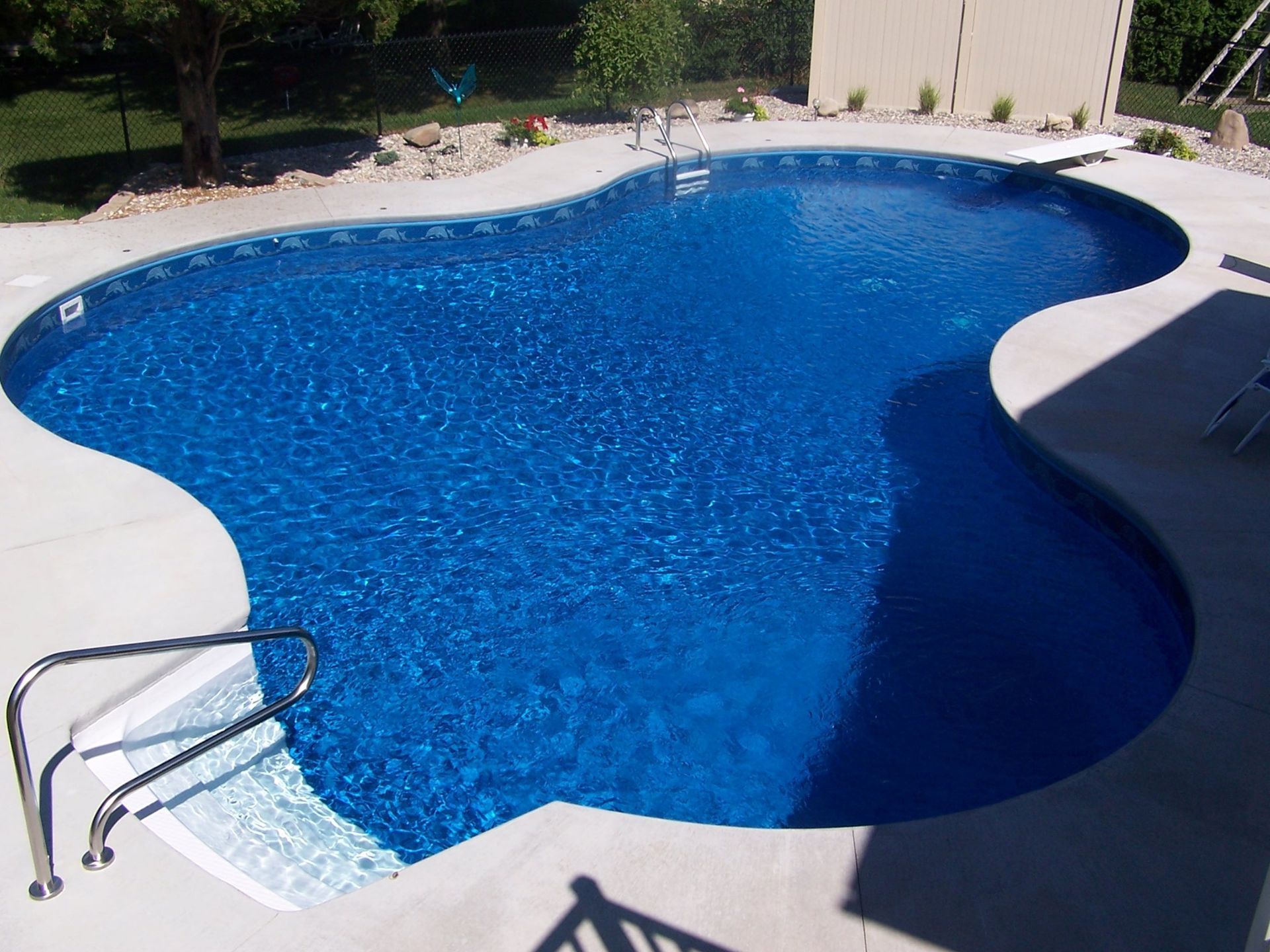 A large blue swimming pool with stairs leading to it