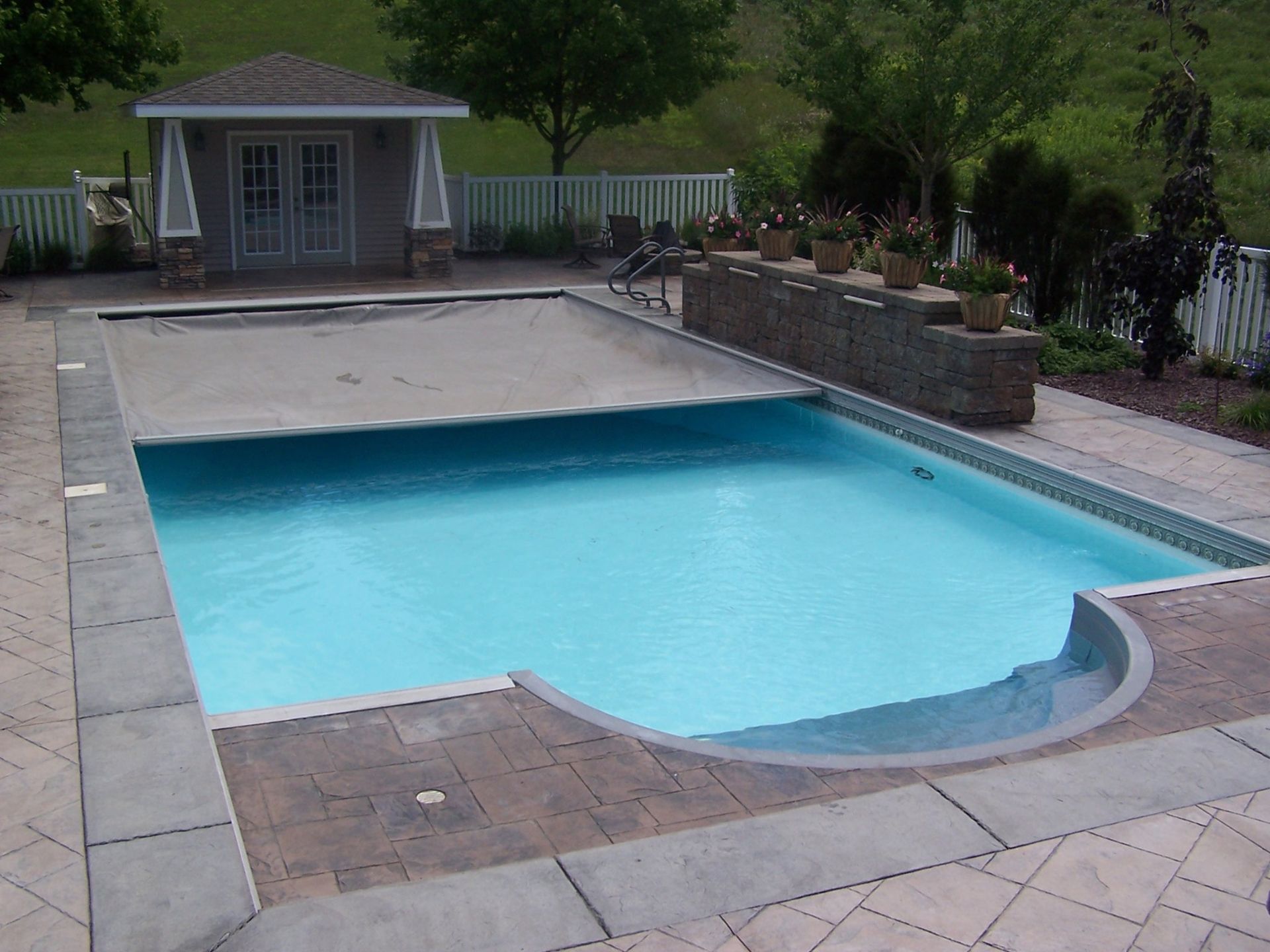 A large swimming pool with a shed in the background