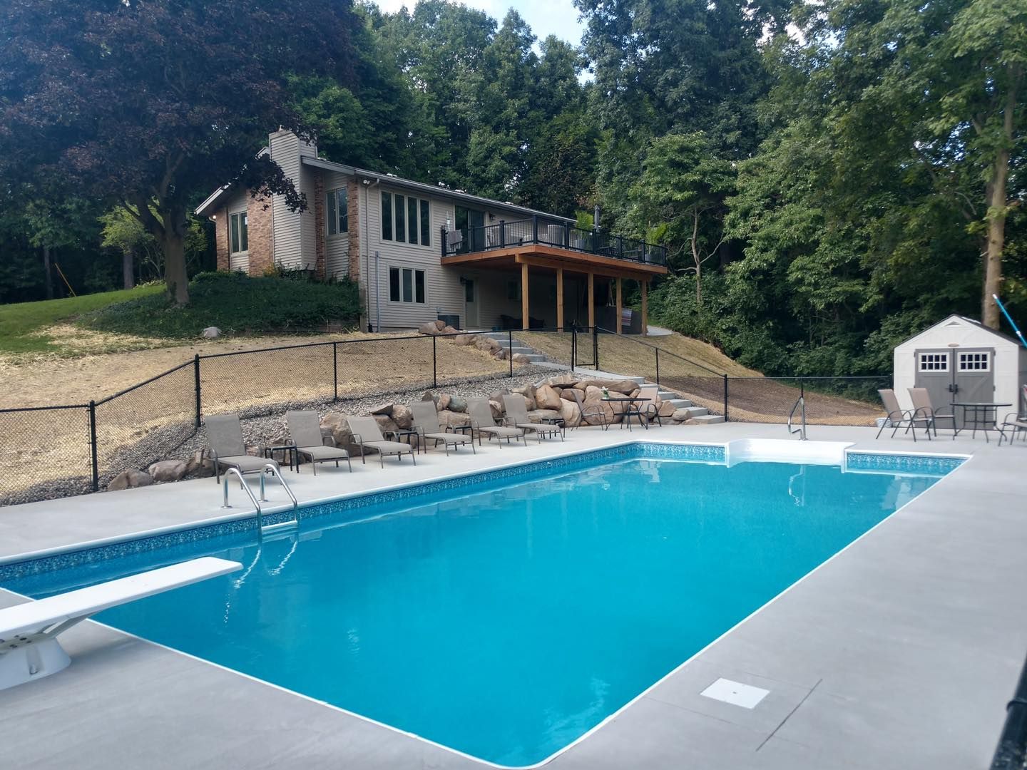 A large swimming pool with a house in the background