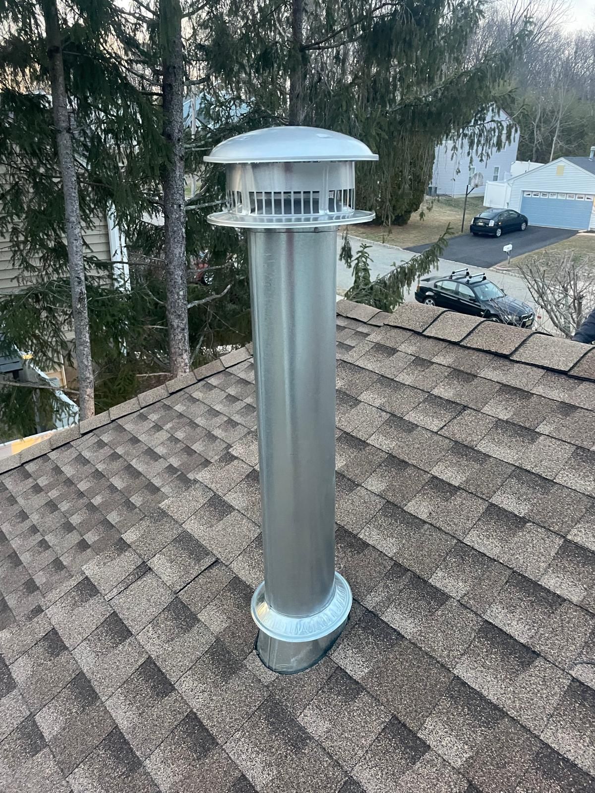 A metal chimney is sitting on top of a roof.