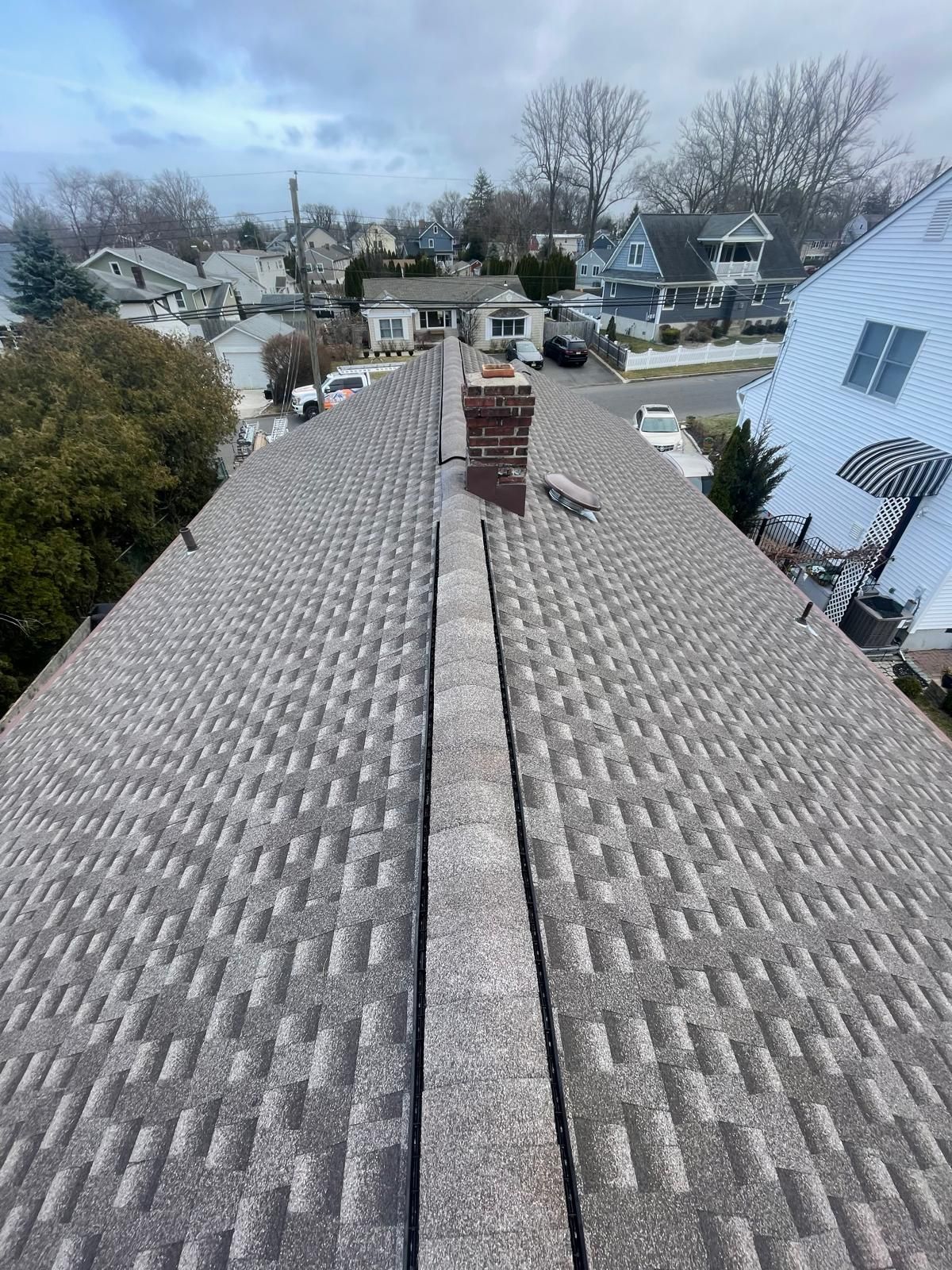 A roof with a chimney on top of it in a residential area.
