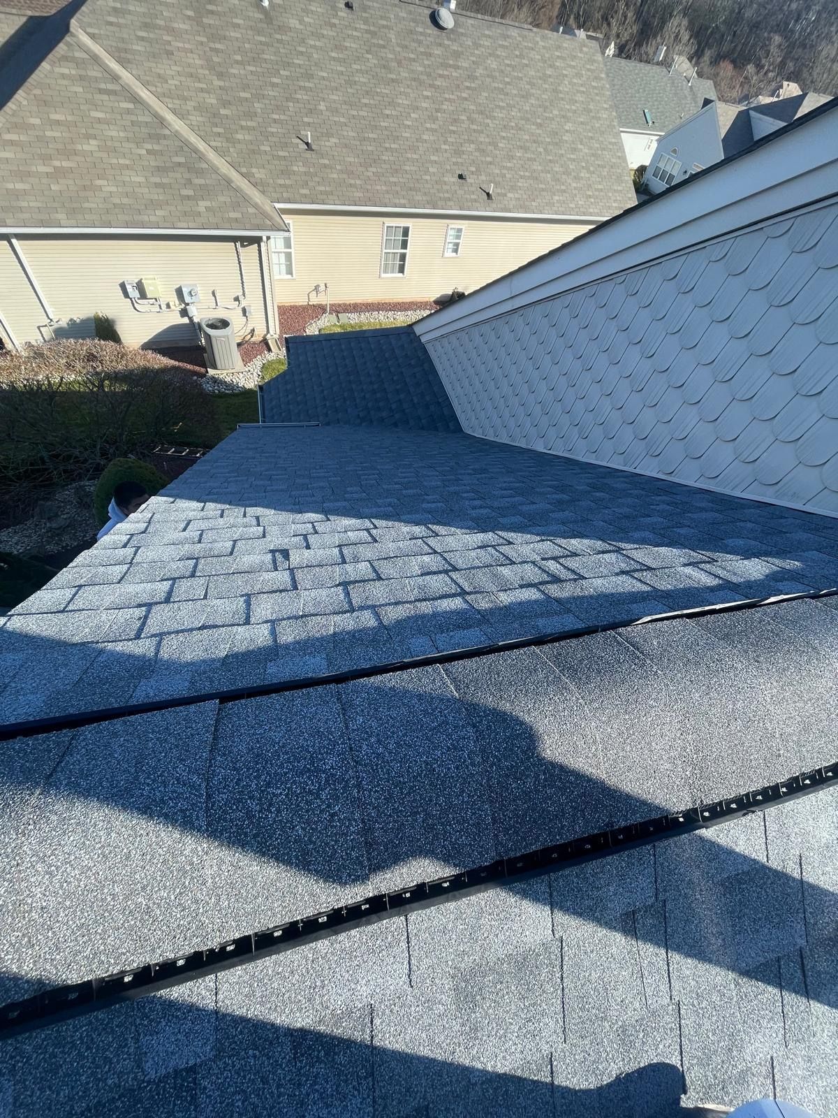 A person is standing on the roof of a house.