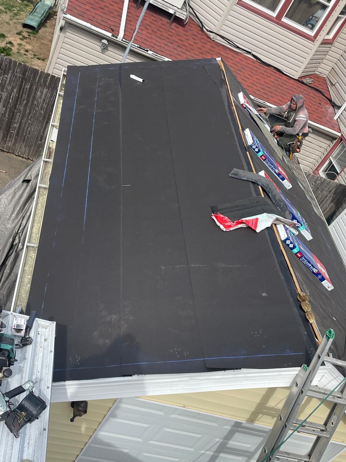 A man is working on the roof of a house.