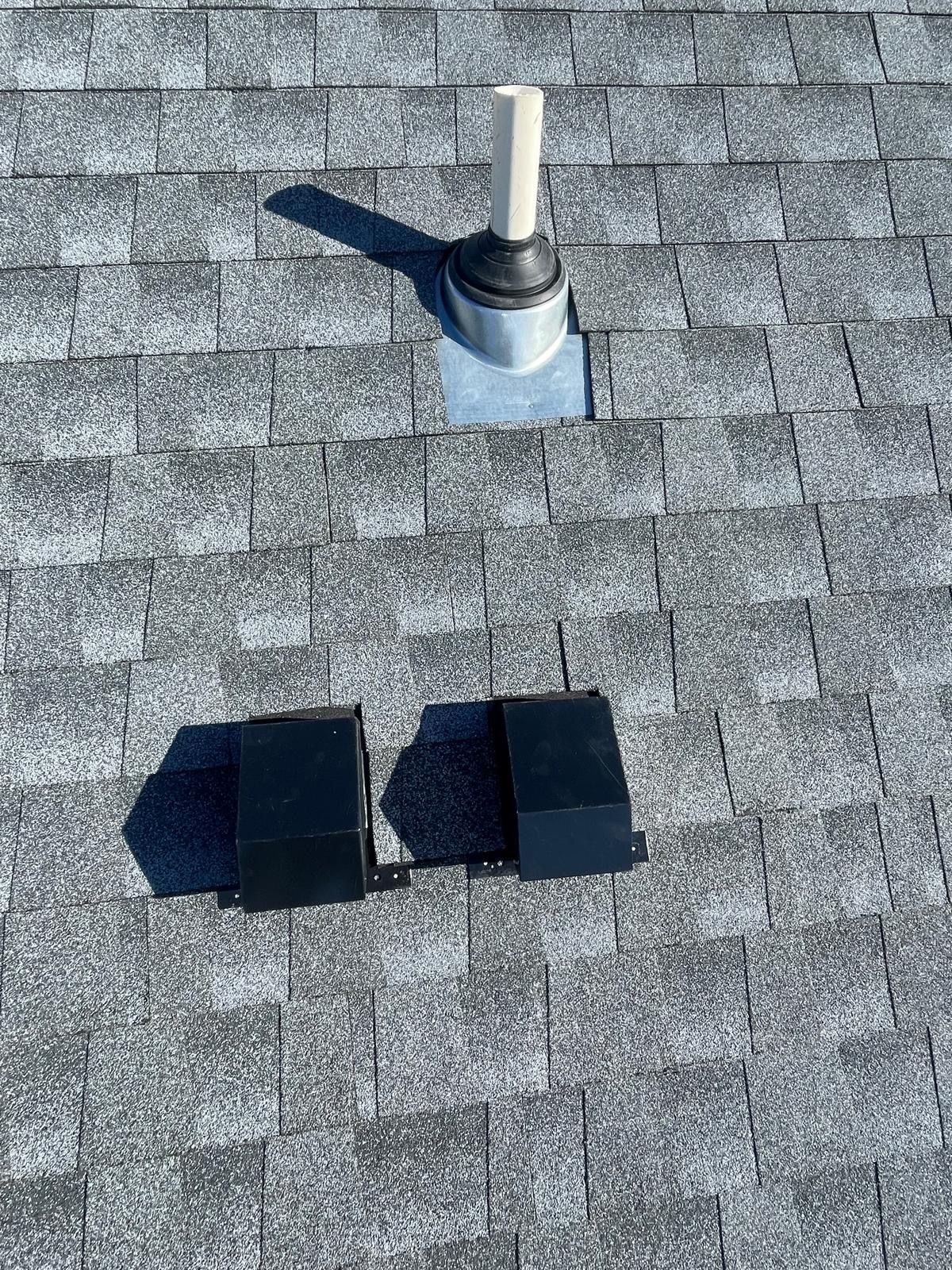 A roof with a hole in it and a pipe coming out of it.