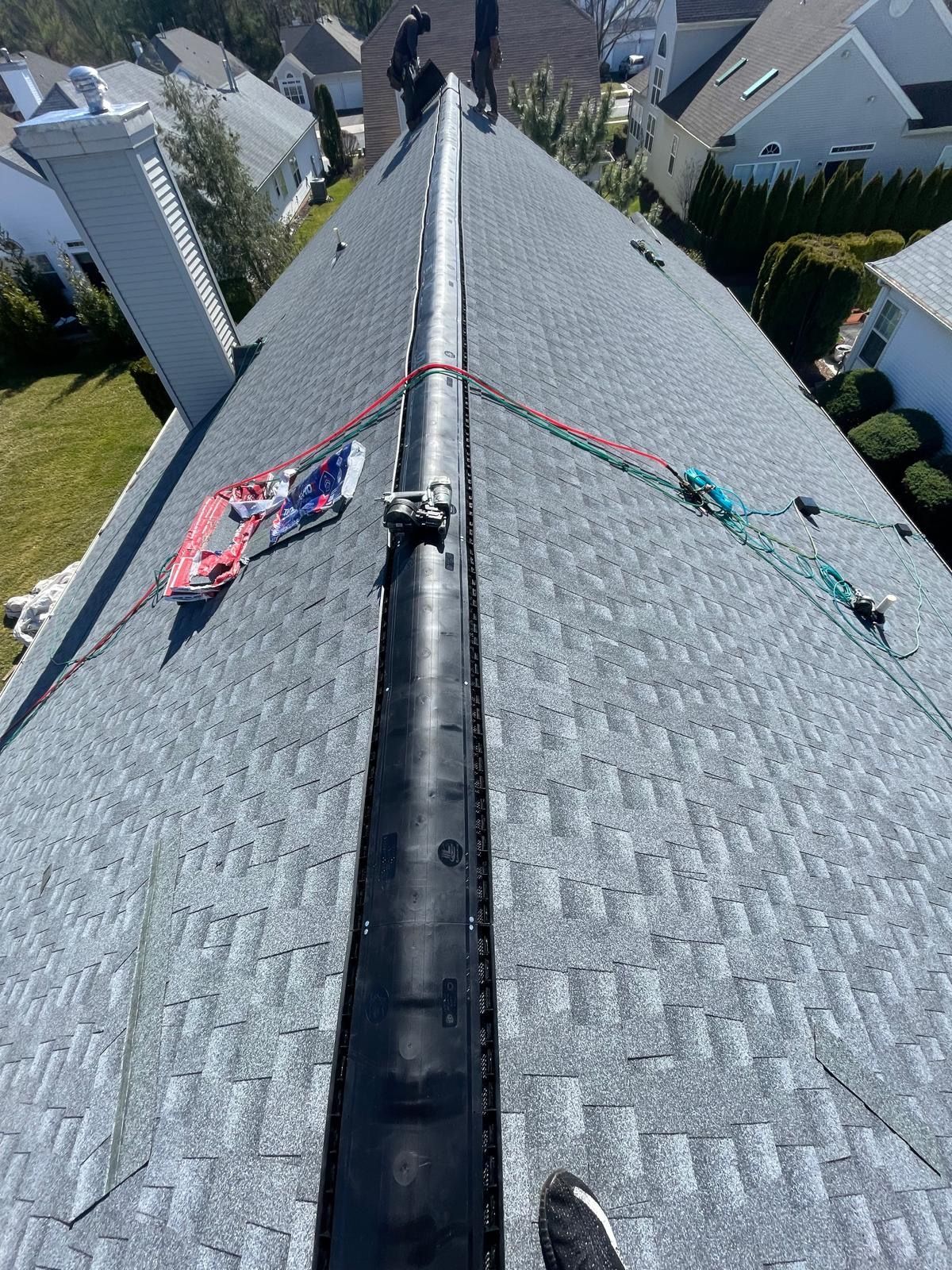 A man is working on the roof of a house.