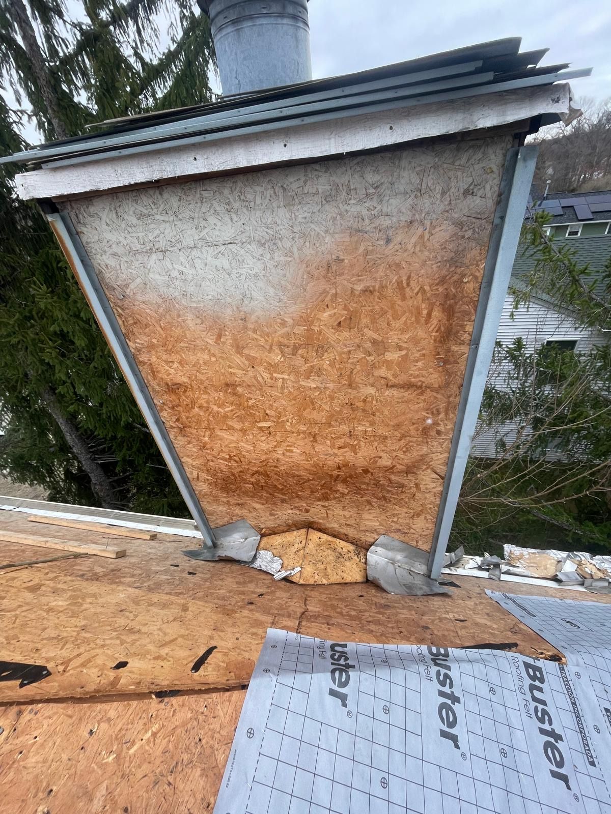 A chimney is sitting on top of a wooden roof.