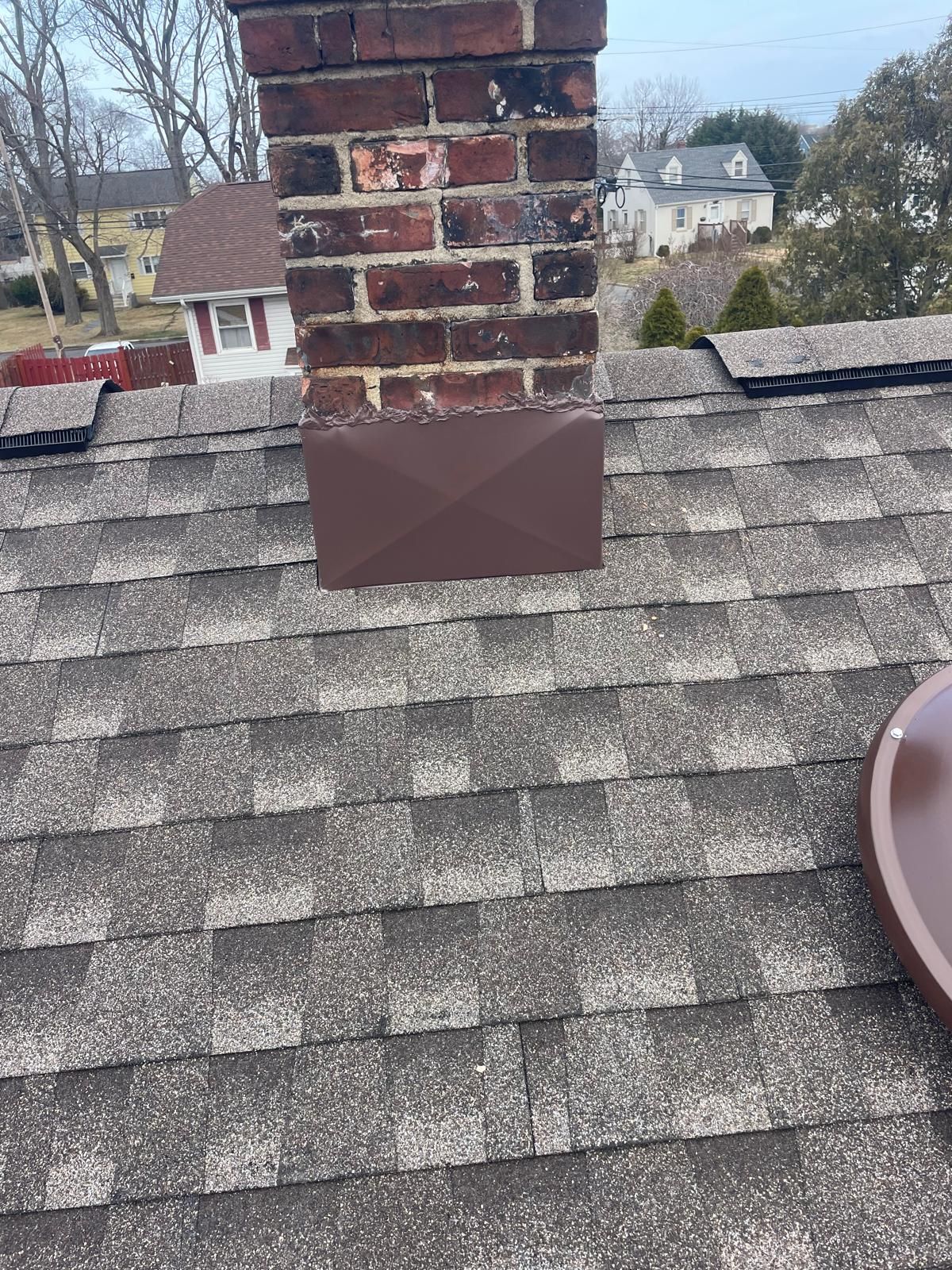 A close up of a roof of a house with a window and gutter.
