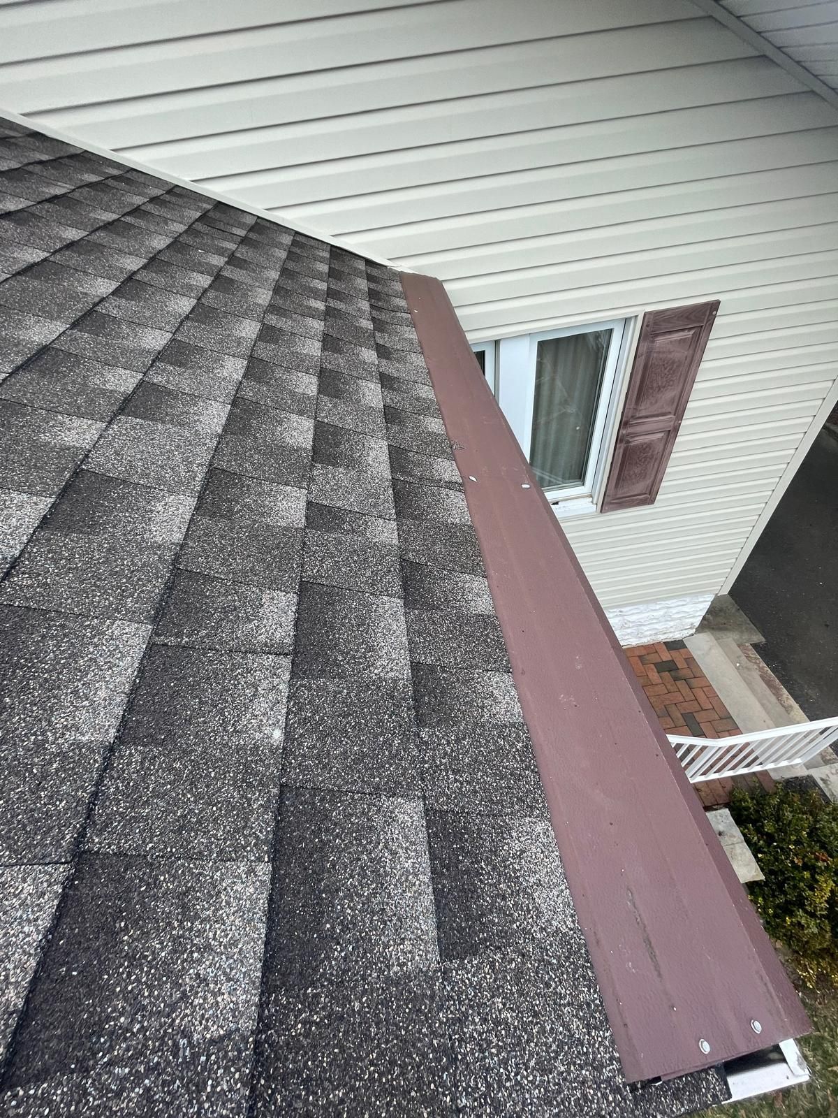 A close up of a roof of a house with a window and gutter.
