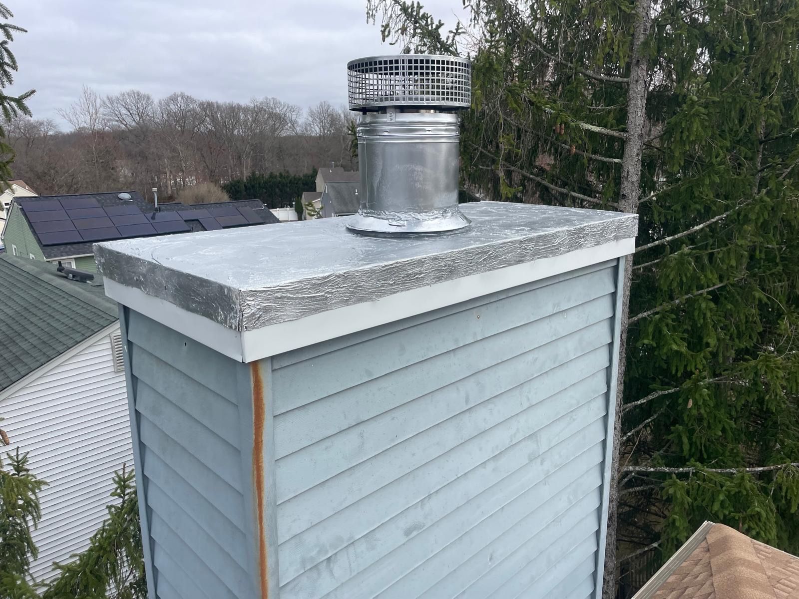 A blue house with a chimney on top of it.