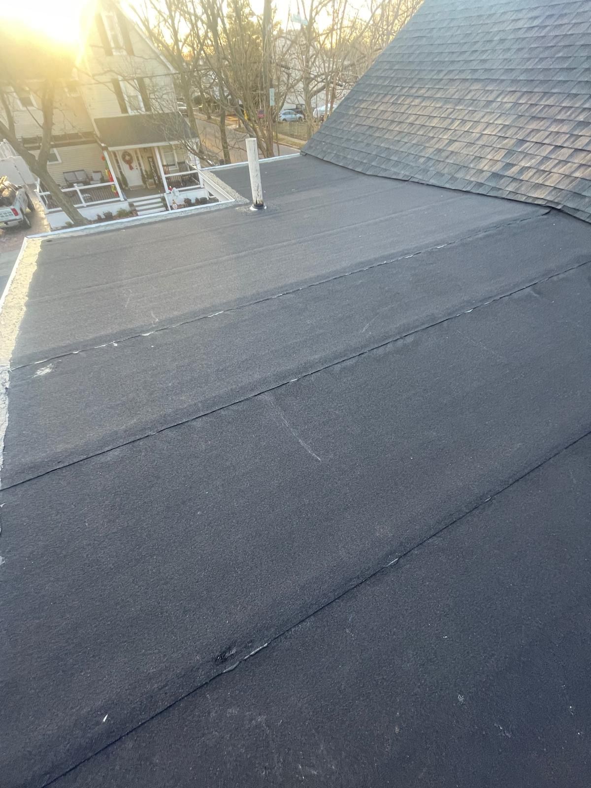 A black roof with a chimney on top of it.