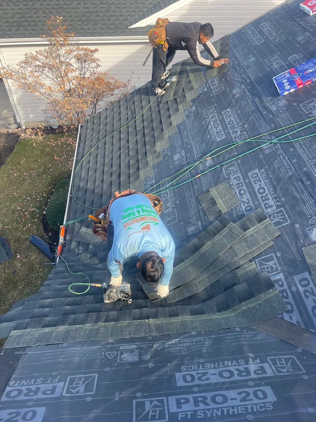 Two men are working on the roof of a house.