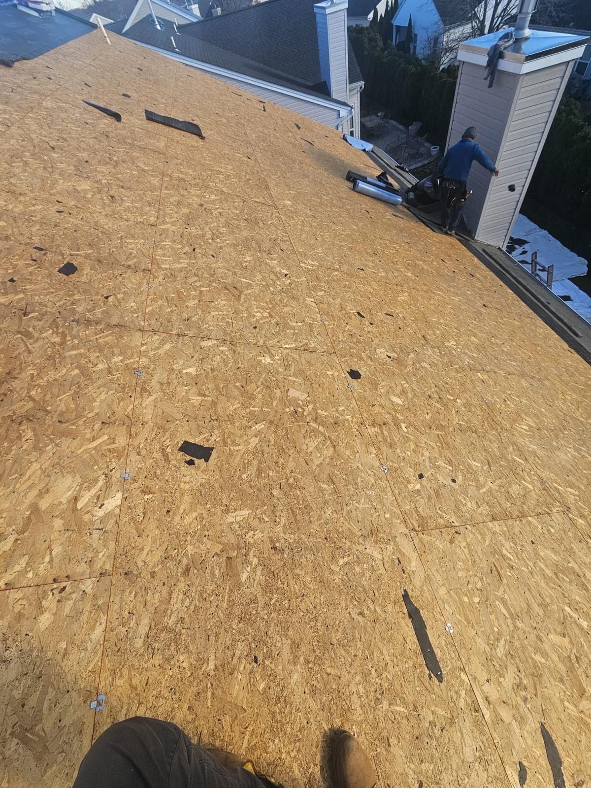A person is standing on top of a wooden roof.