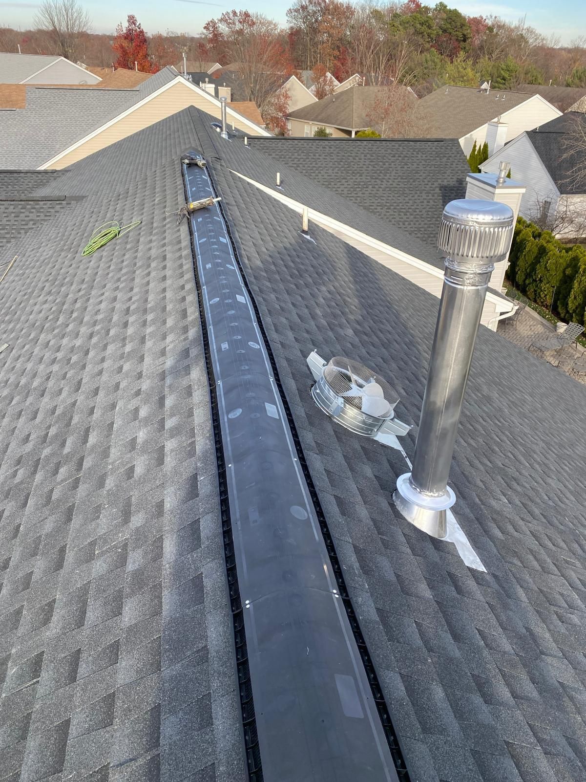 There is a chimney on the roof of a house.