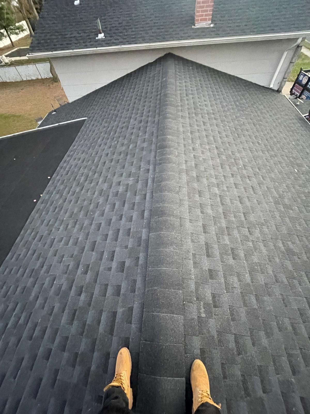 A person is standing on the roof of a house.