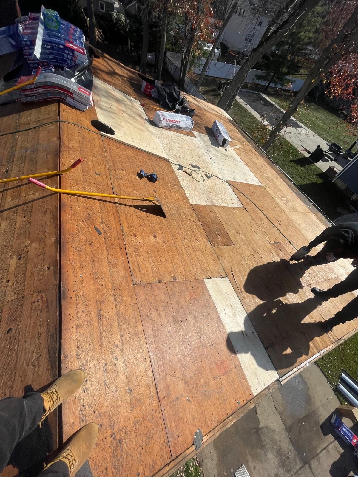 A group of people are working on a wooden roof.