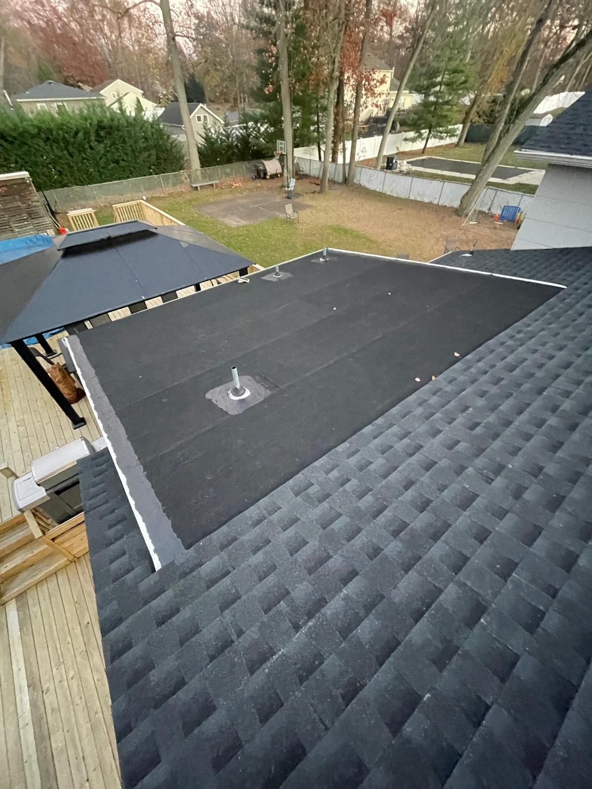 The roof of a house with a black roof and a black umbrella.