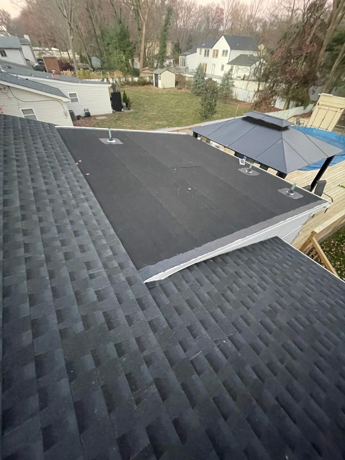 A black roof with a black umbrella on top of it.
