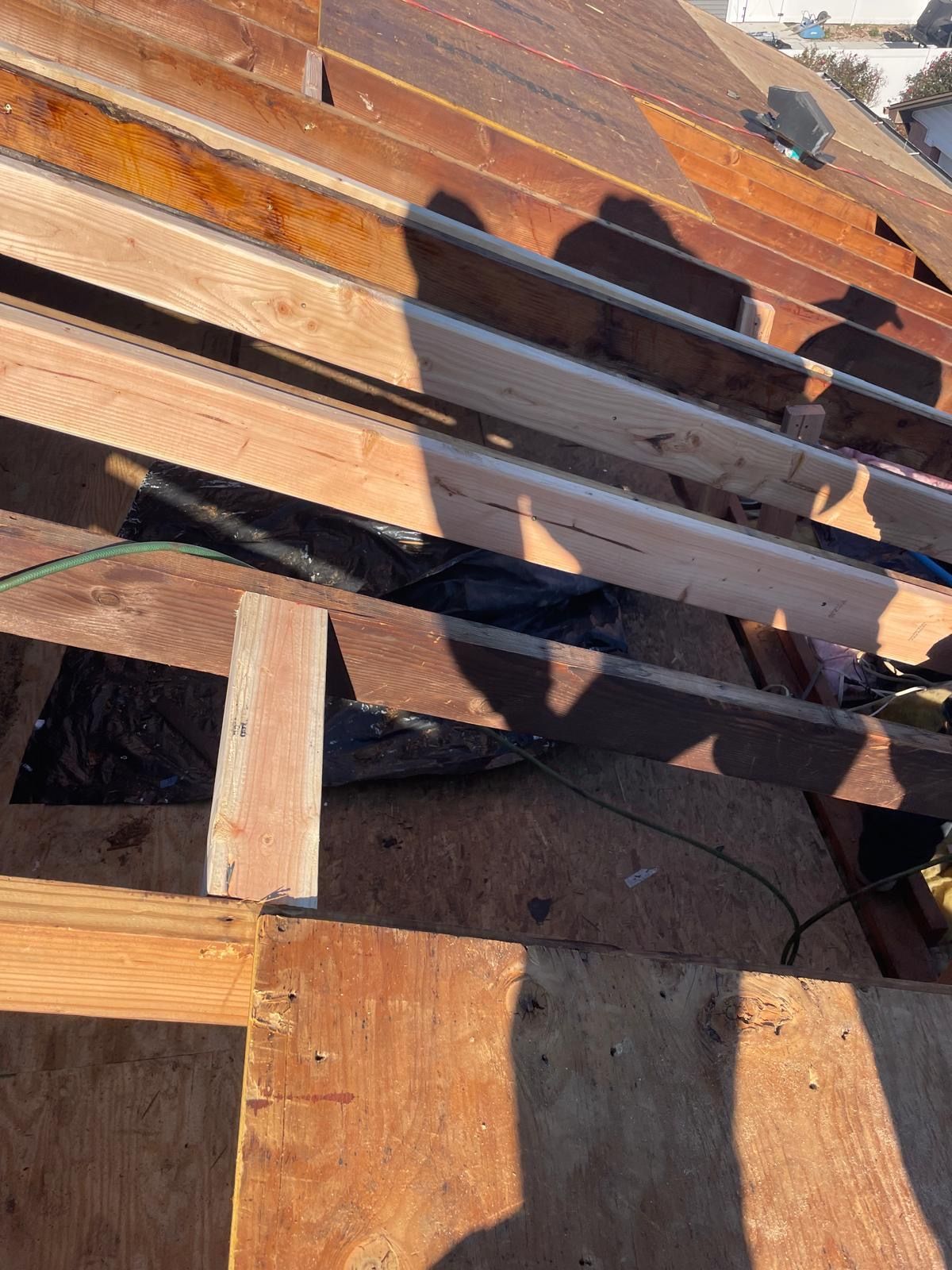 A bunch of wooden beams are sitting on top of each other on a roof.