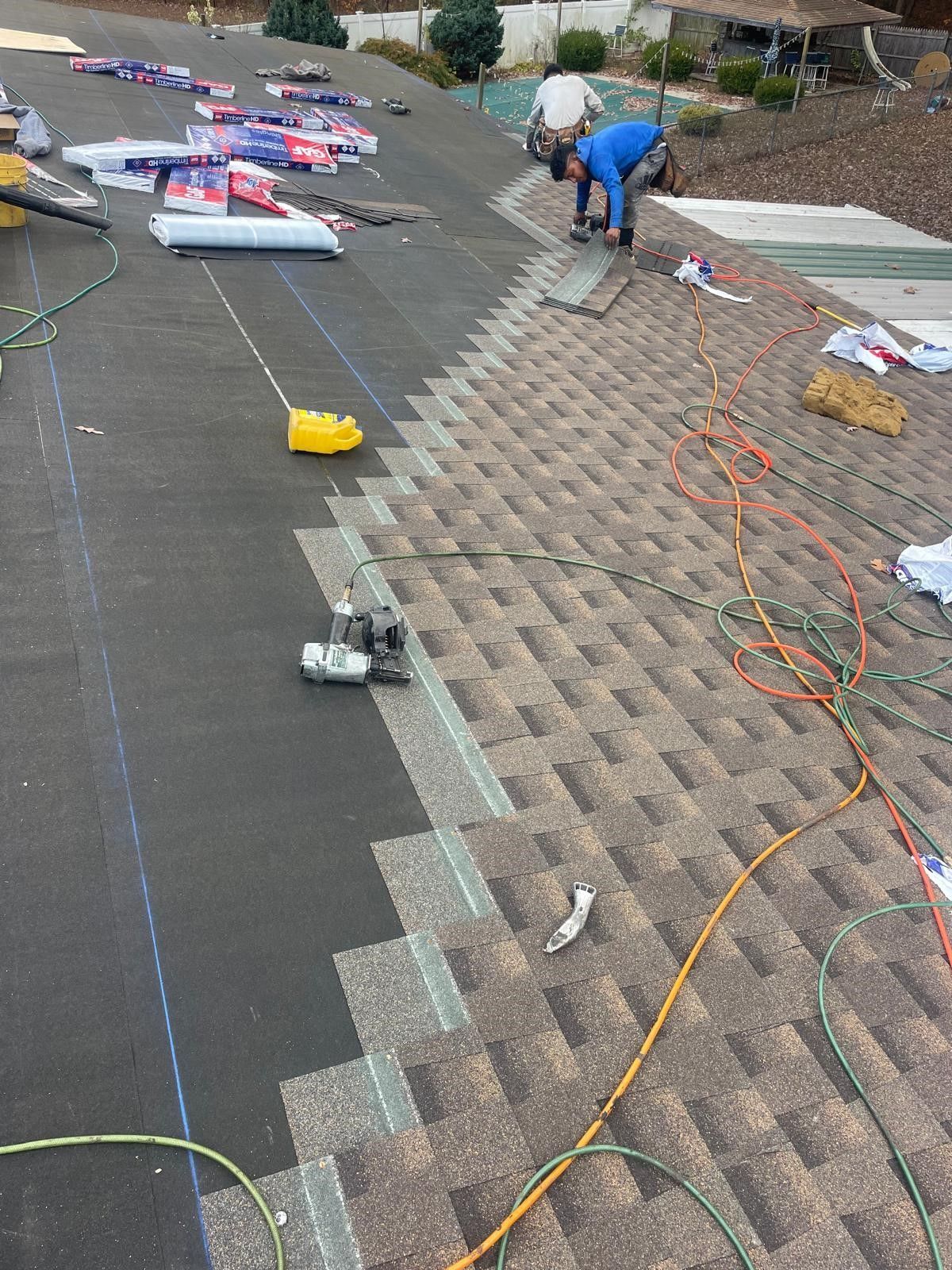 A group of men are working on a roof.