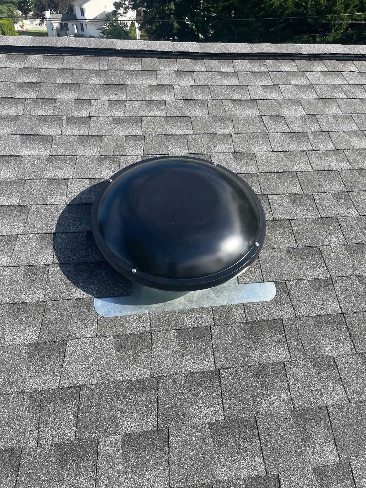 A black dome is sitting on top of a roof.