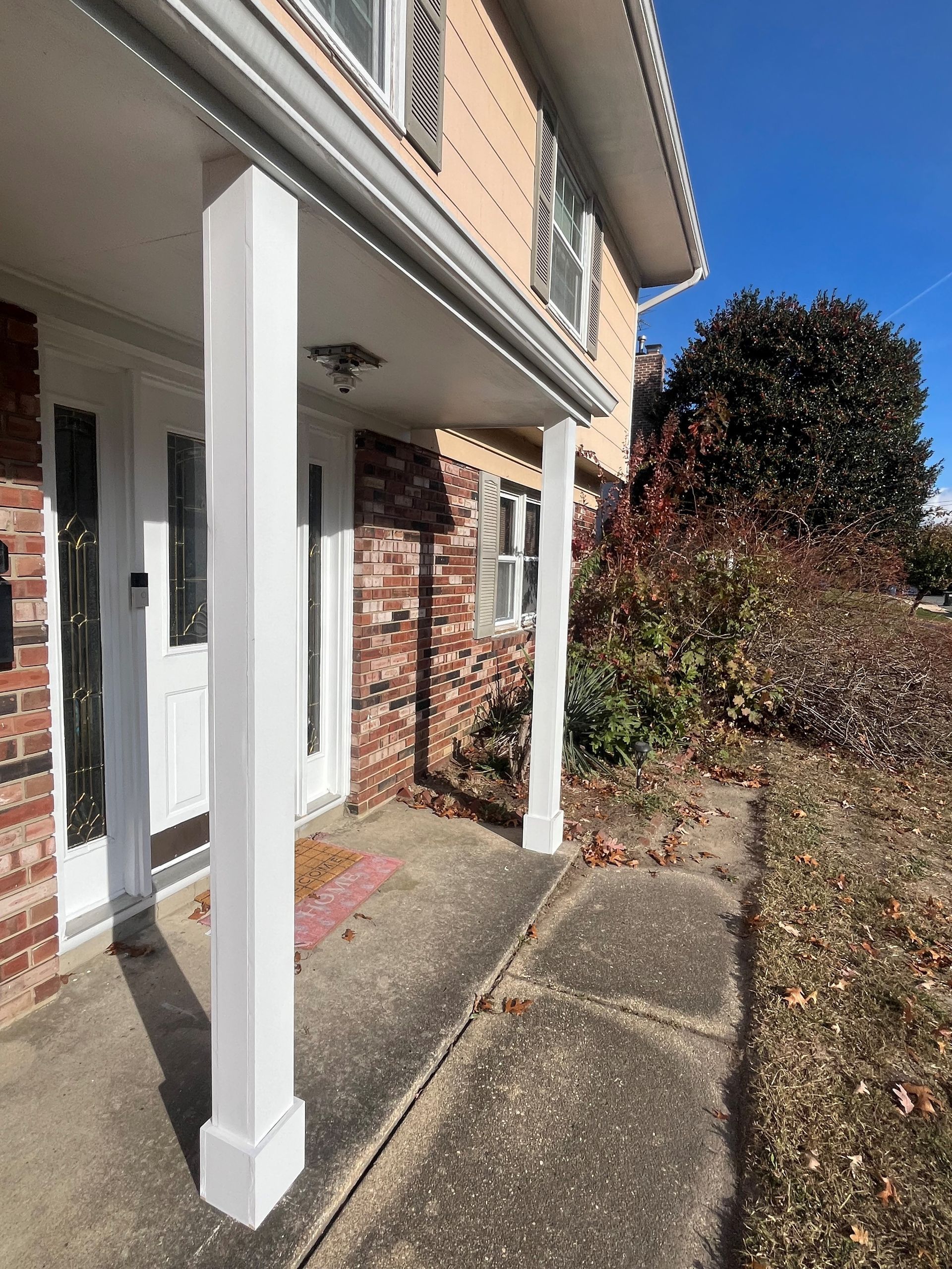 A brick house with a porch and a white door