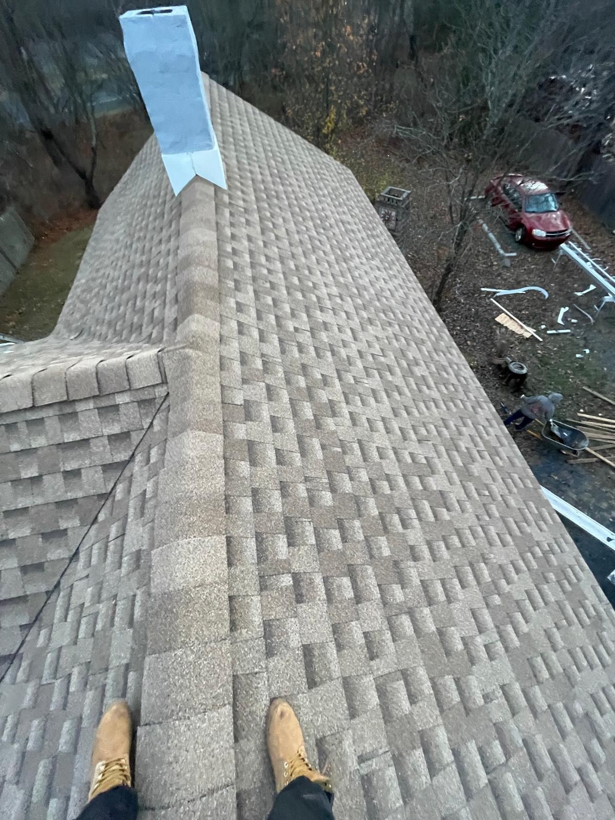 A person is standing on the roof of a house