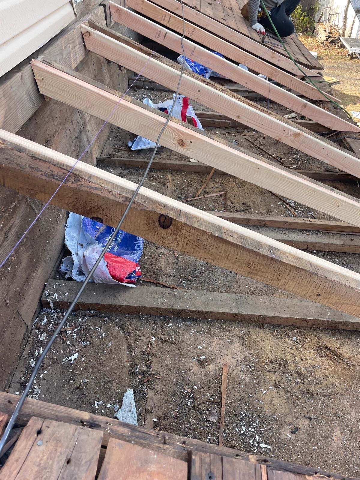 A bunch of wooden beams are laying on the ground