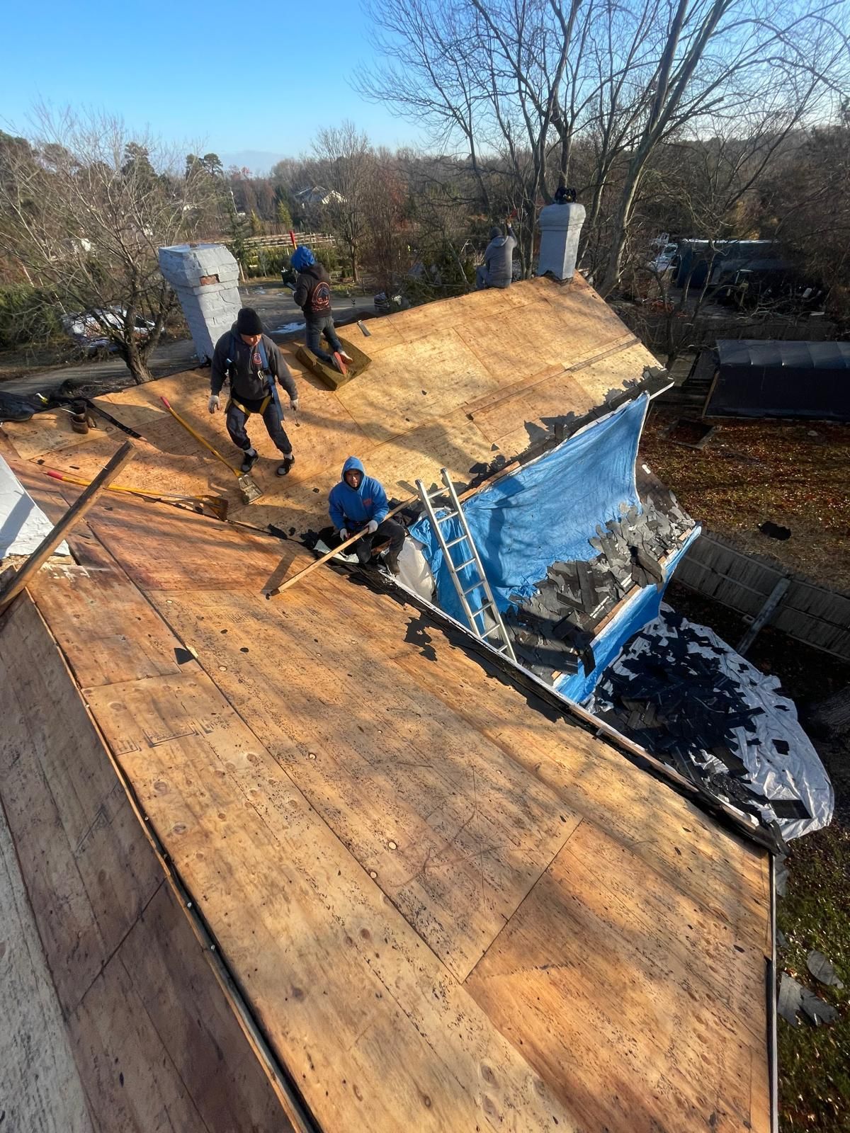 Two men are working on the roof of a house.